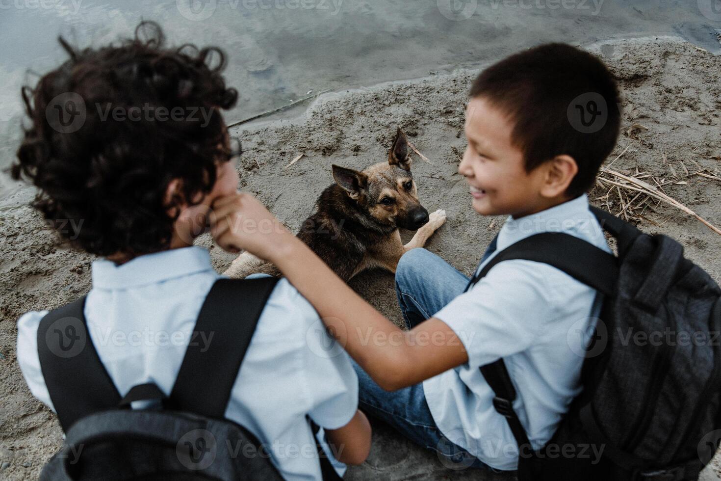 Happy boys in school uniform sitting with backpack and dog photo