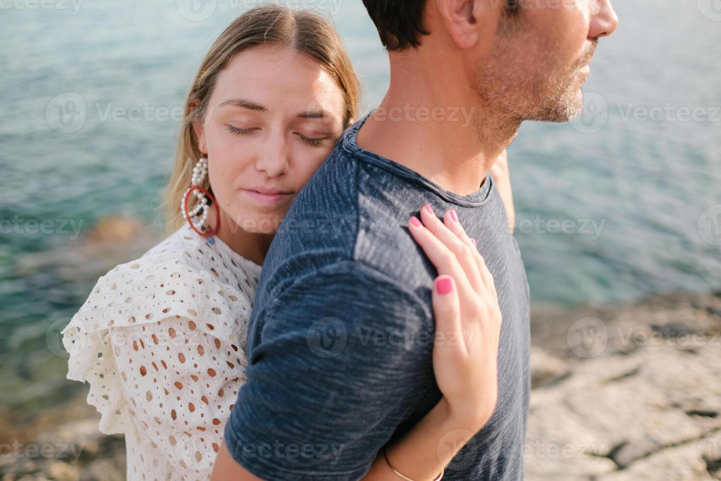 Young woman hugging man on wild beach photo