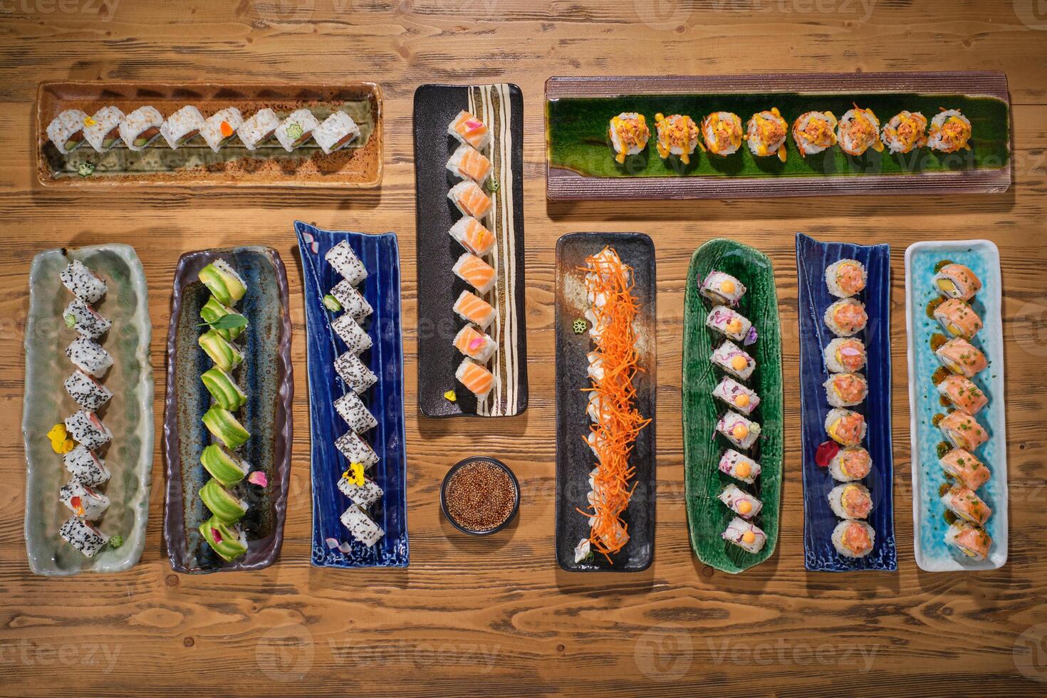 Set of sushi rolls on plates on wooden table in restaurant photo