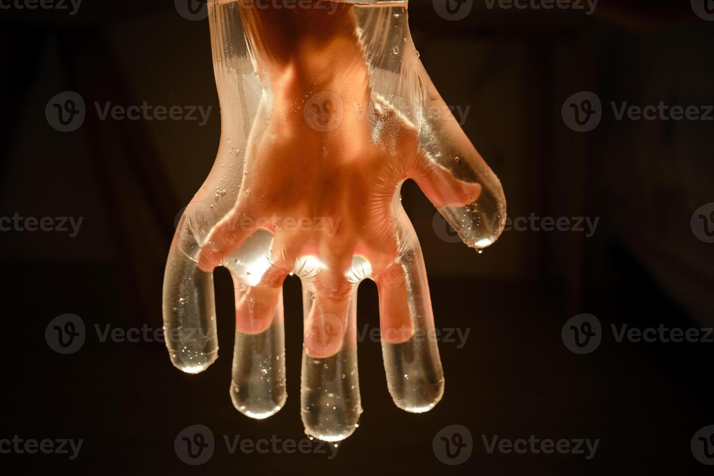 Crop child in plastic glove with water photo