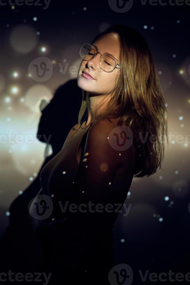 Young female with closed eyes under sparks photo