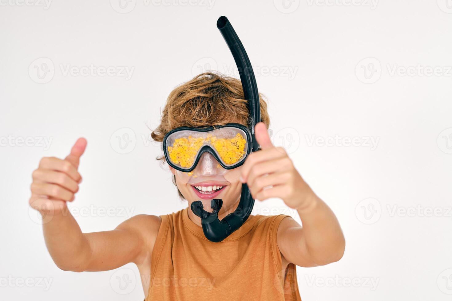 Smiling boy in snorkeling mask showing thumbs up photo