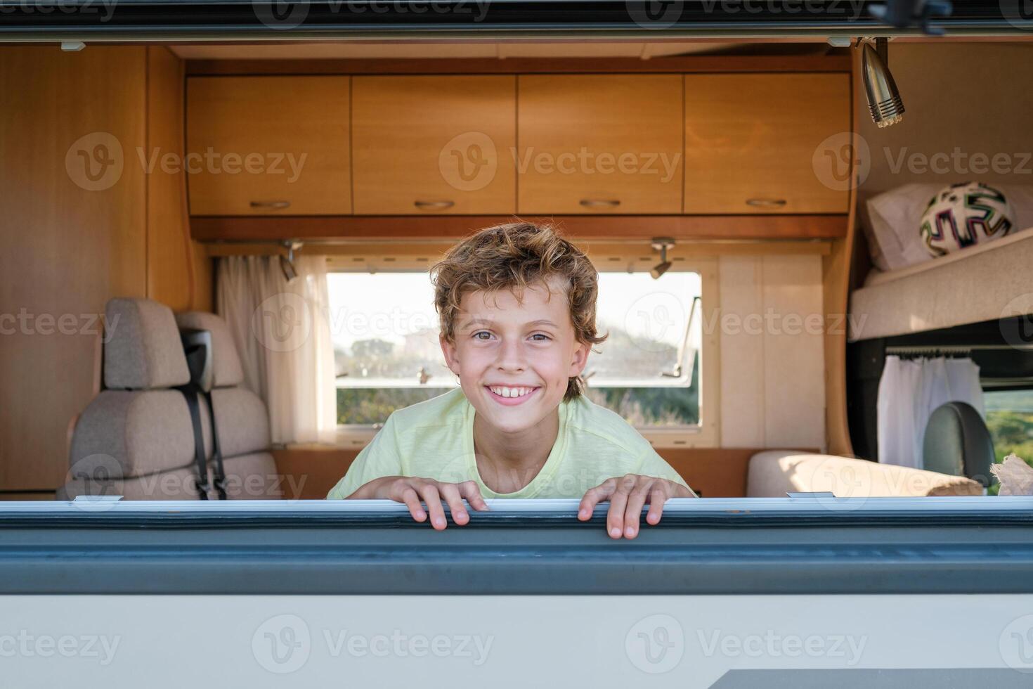 Delighted boy behind caravan window photo