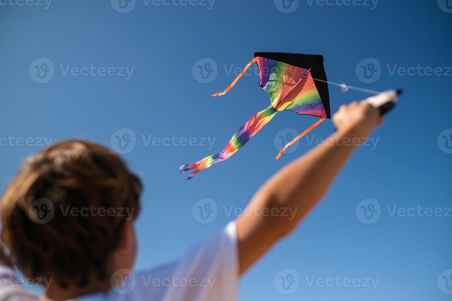 Child playing with rainbow kite photo