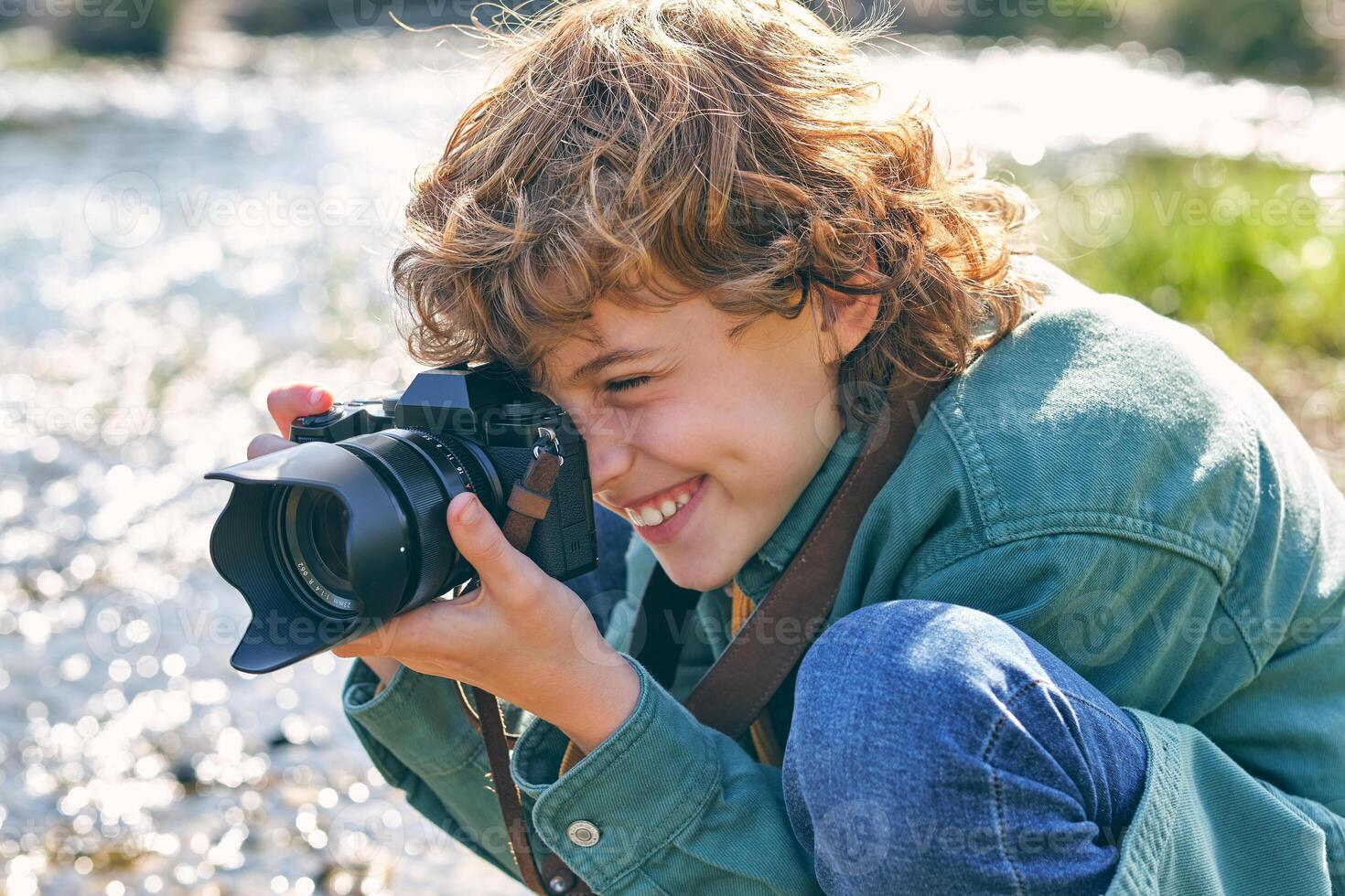 Smiling boy taking photo of nature on shore