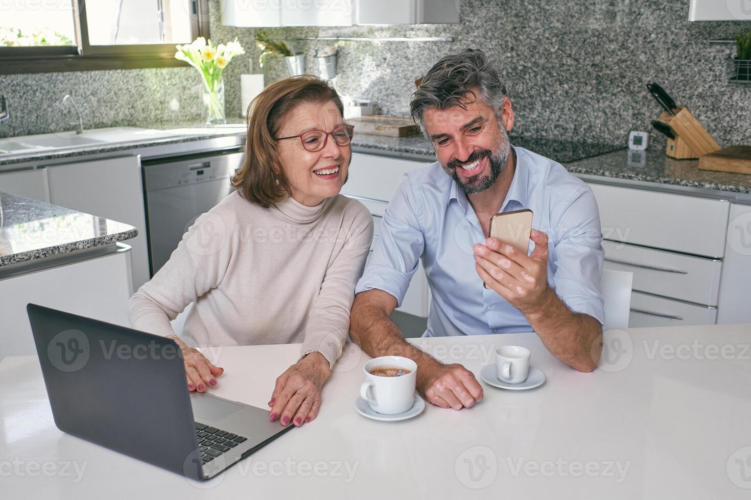 Happy mother with middle aged son having call on smartphon photo