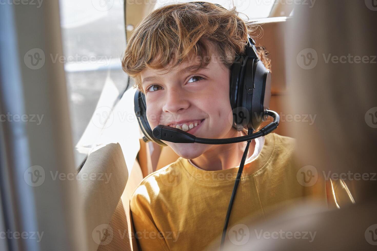 Delighted child smiling during flight in aircraft on sunny day photo