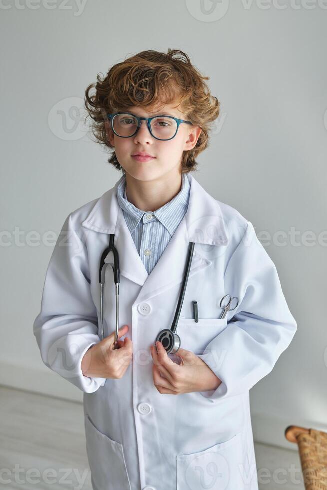 Intelligent boy in medical uniform with stethoscope photo
