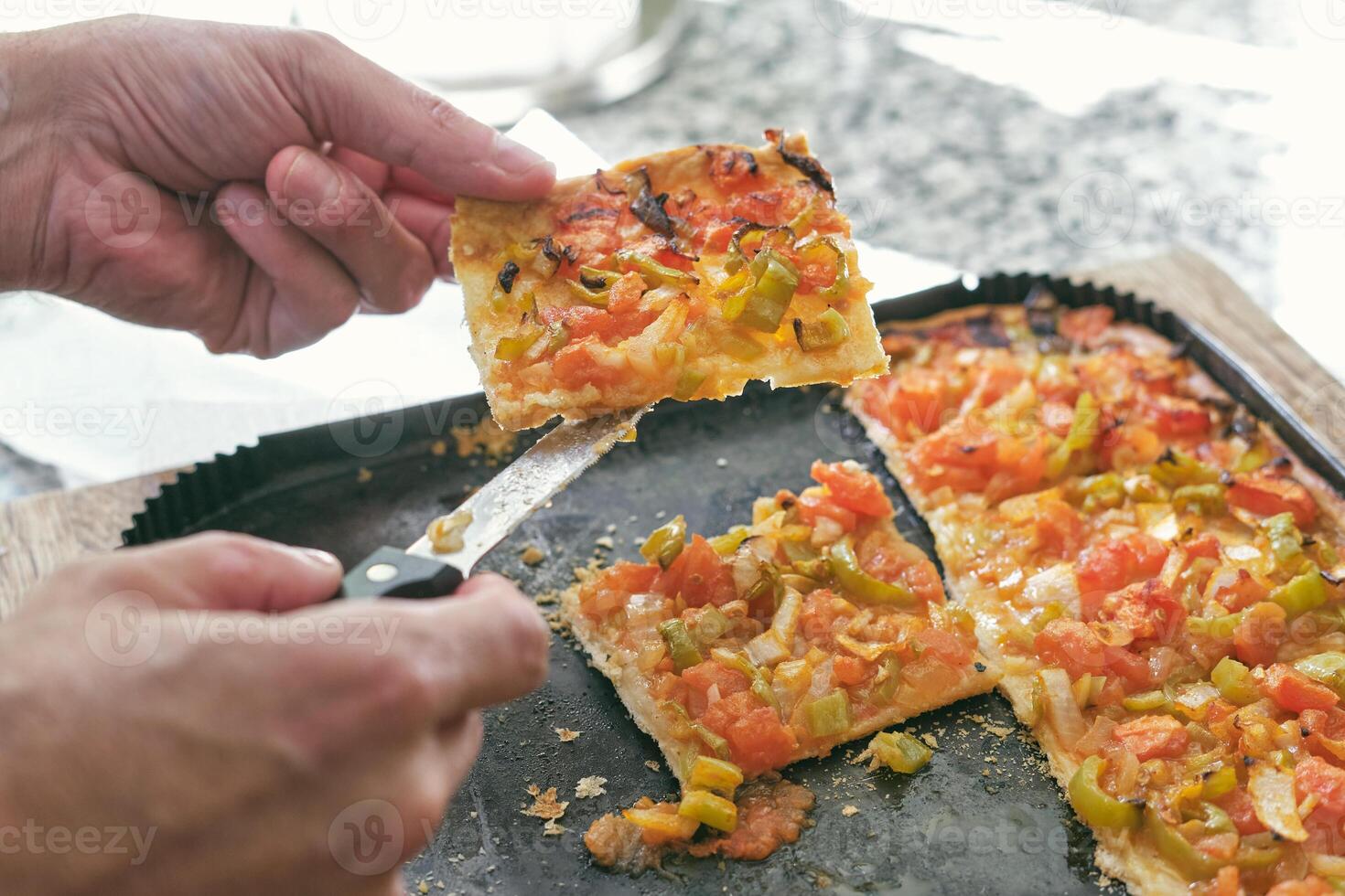 Unrecognizable person showing slice of pizza photo