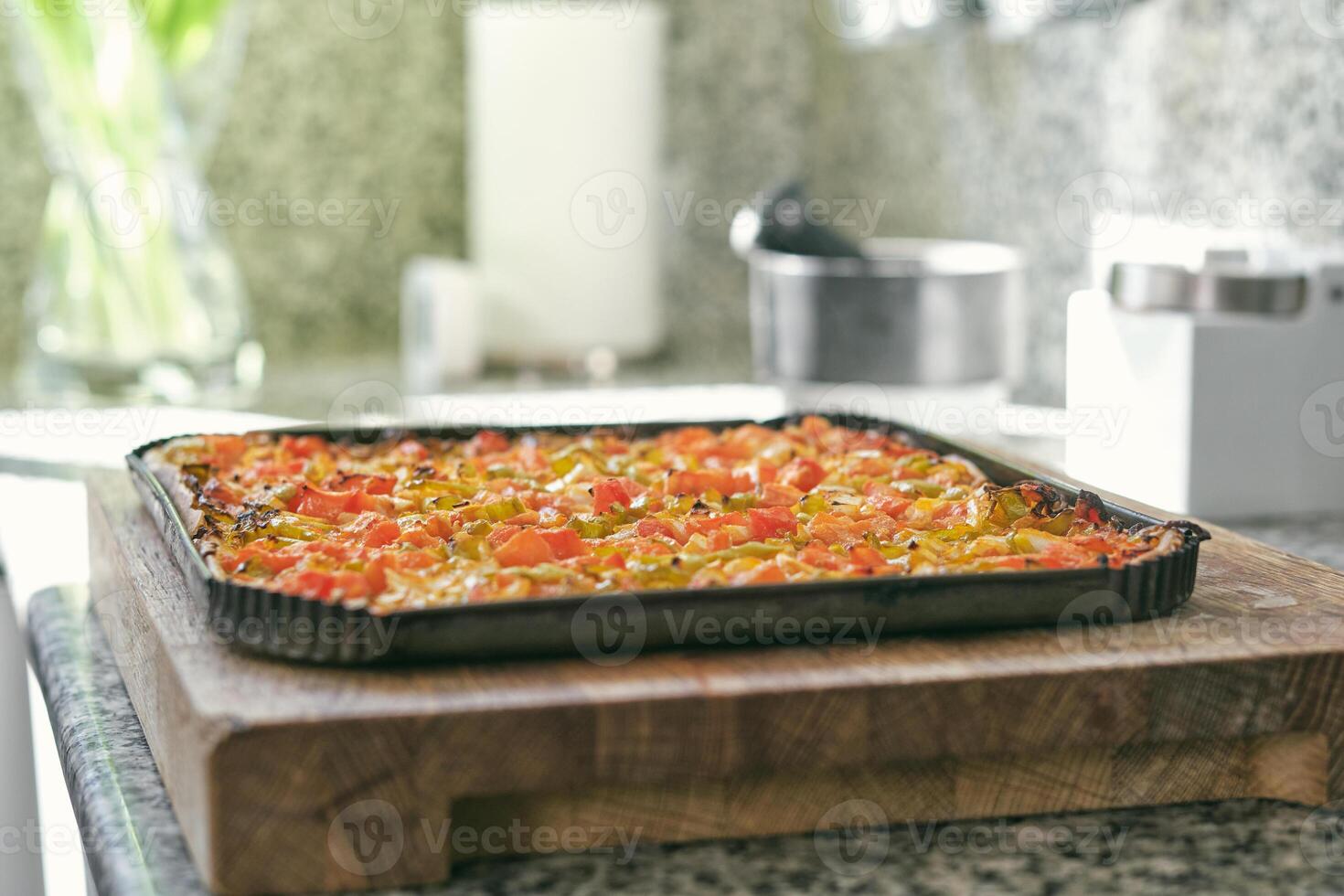 Assorted pizza with tomatoes and peppers placed on tray photo