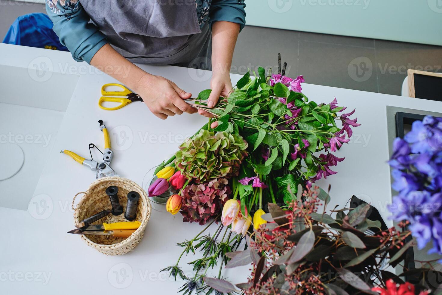 Unrecognizable female florist arranging bouquet of flowers photo