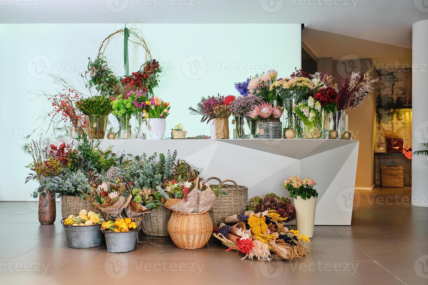 Various blooming flowers placed on counter and floor in floral s photo