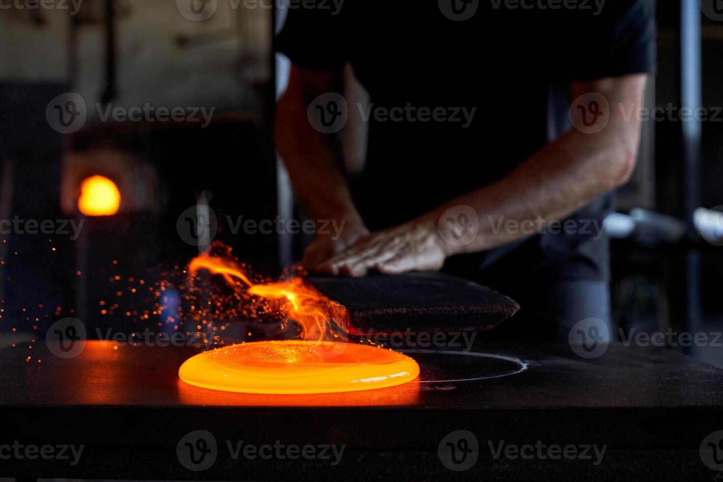 Crop craftsman forming liquid glass in workshop photo