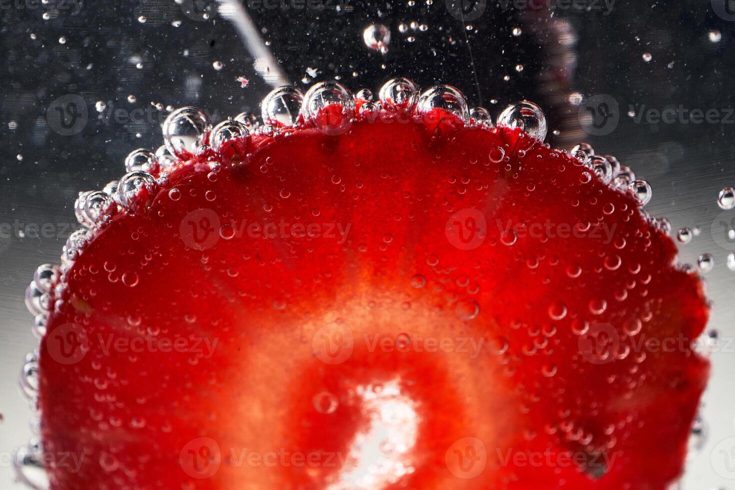 Slice of strawberry covered with bubbles photo
