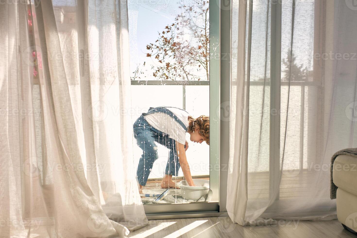 Child cleaning windows at home photo