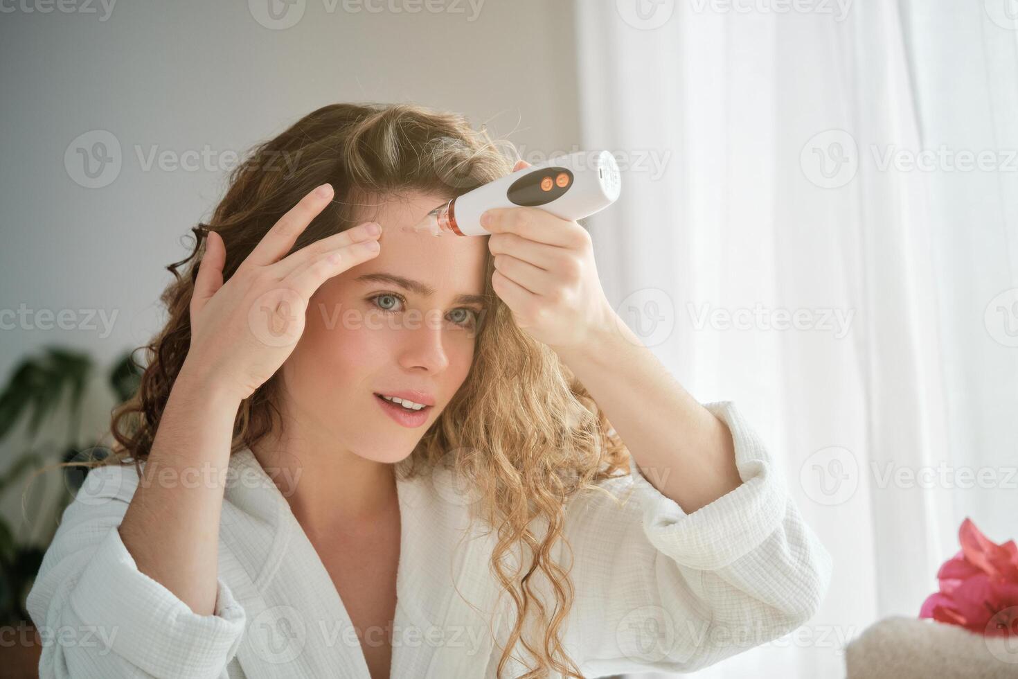 Woman using blackhead cleaner near mirror photo