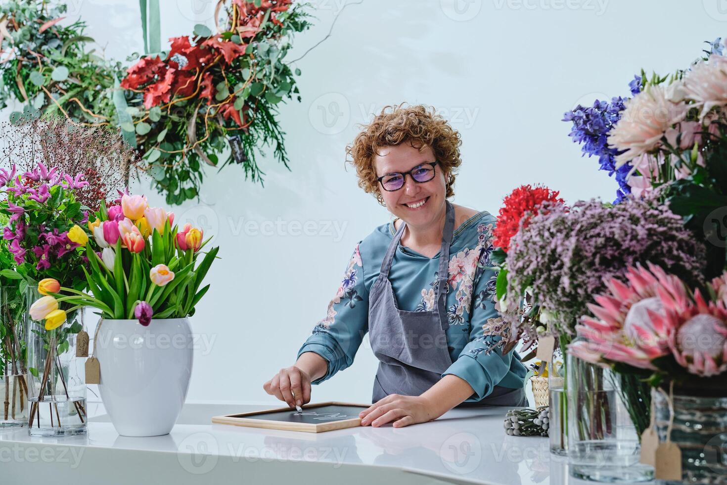 Happy woman working in floral shop photo