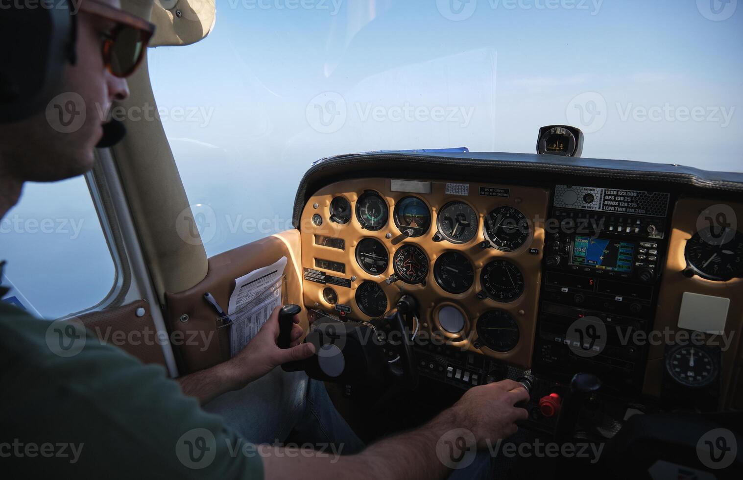 Crop focused pilot operating helicopter on clear day photo