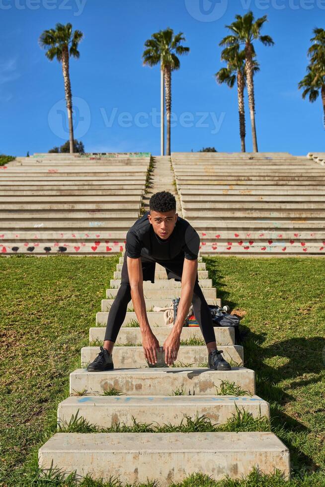 Hispanic man stretching on staircase photo