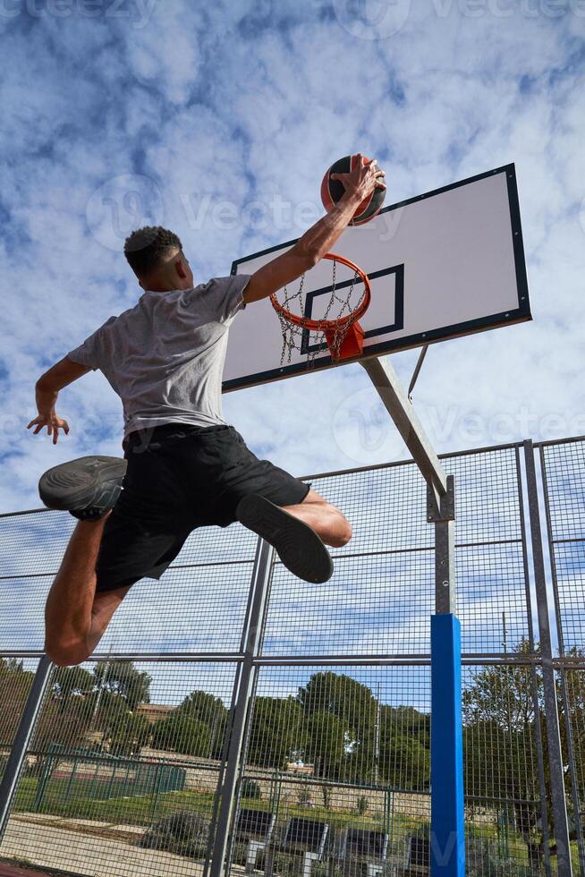 Faceless basketball player jumping on sports ground photo