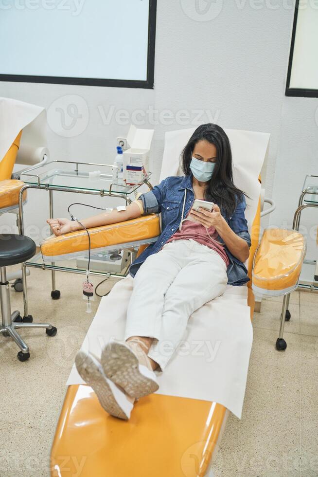 Female patient giving blood in clinic photo
