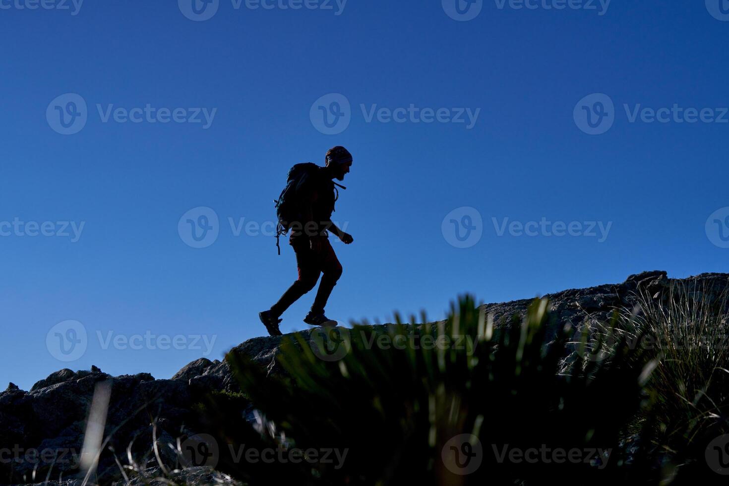 Silhouette of traveling man on rocky hill photo