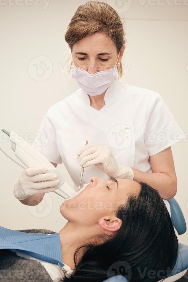 Professional orthodontist doing digital 3D teeth cast in dentist office photo