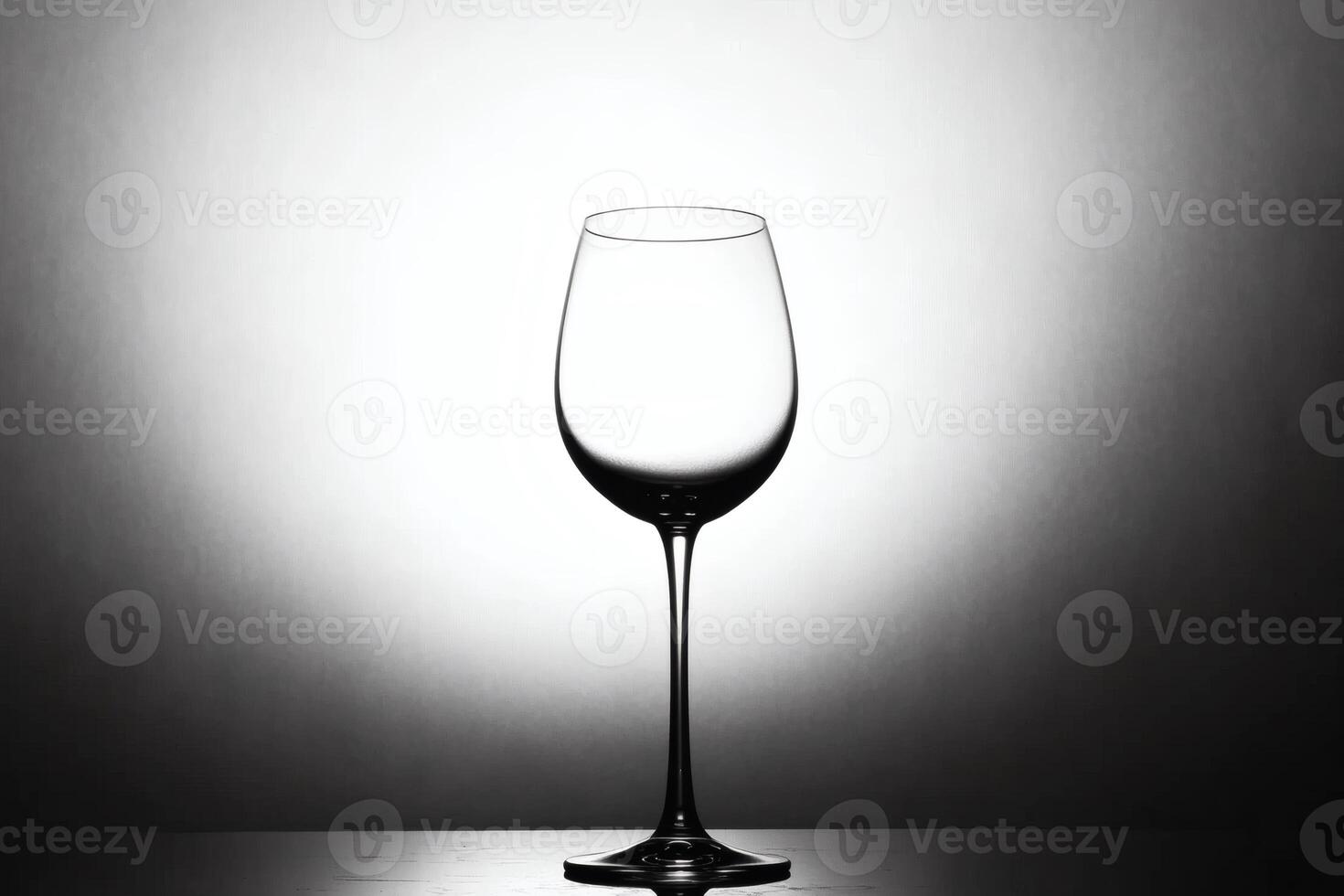 Elegant empty glass stands alone against minimalistic light background in a black and white aesthetic photo