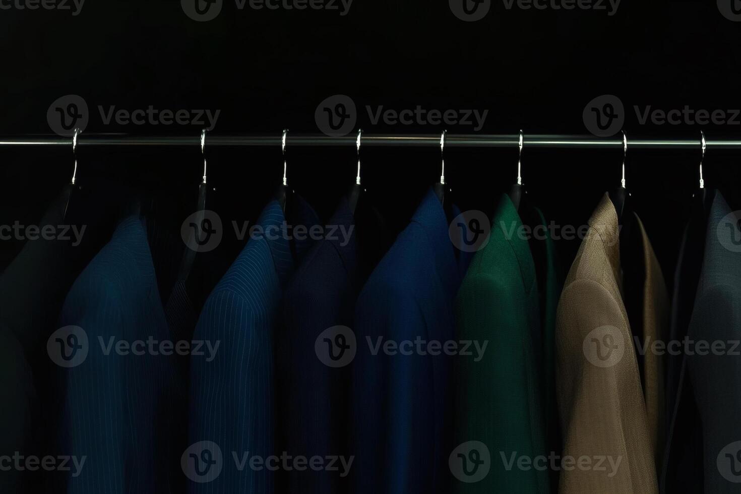Colorful collection of hanging garments arranged on a sleek metal rack in a minimalistic setting at a clothing store during the evening photo