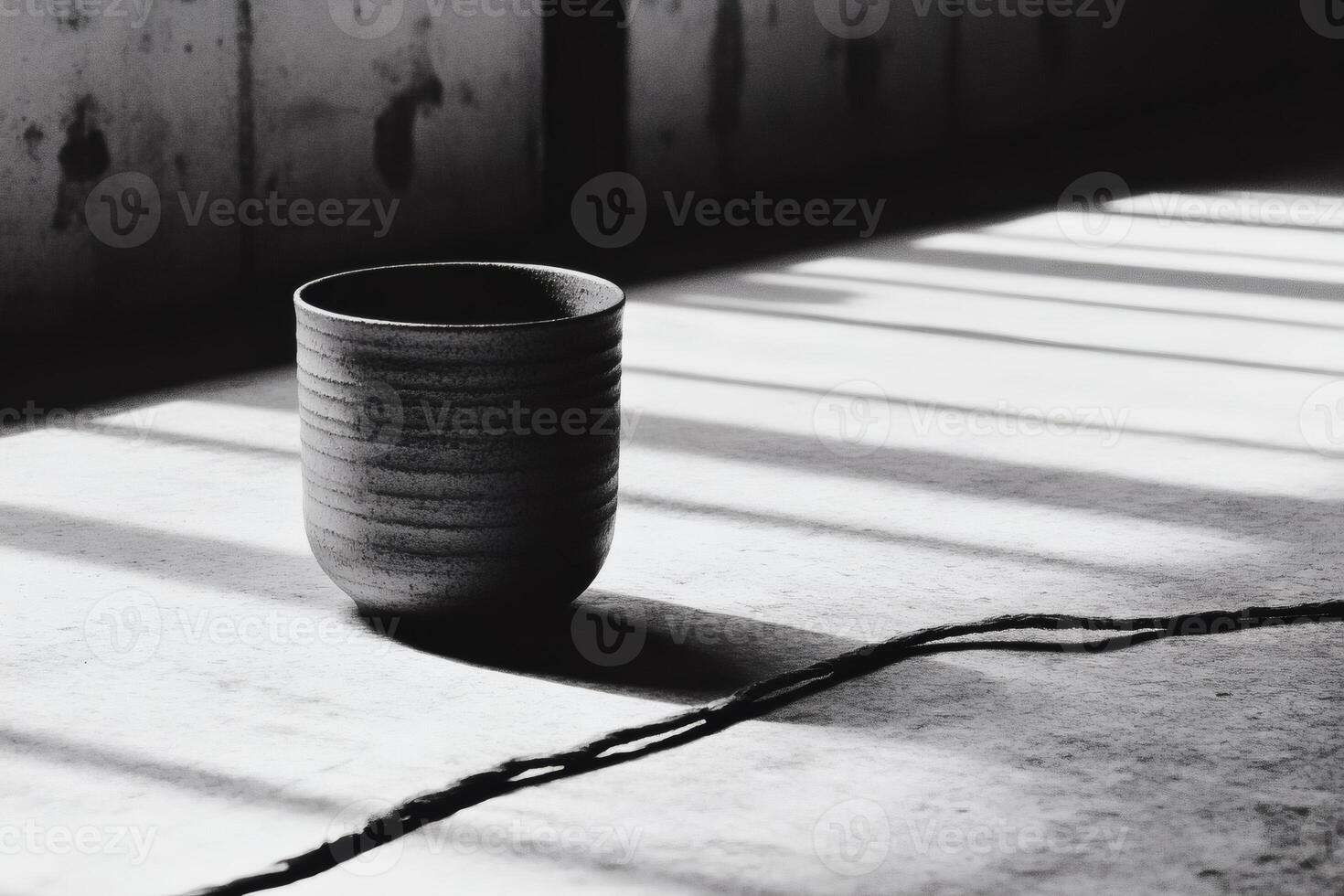Ceramic cup positioned in sunlight casting shadows on a textured surface photo