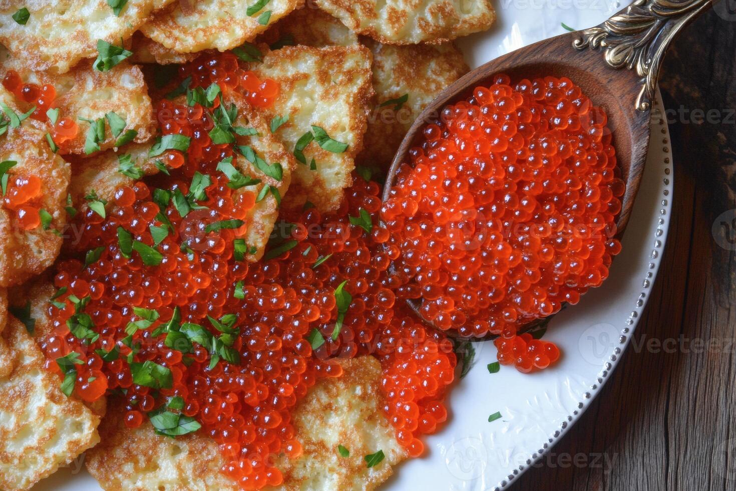 Deliciously prepared potato pancakes topped with bright red caviar and fresh herbs on a decorative platter photo
