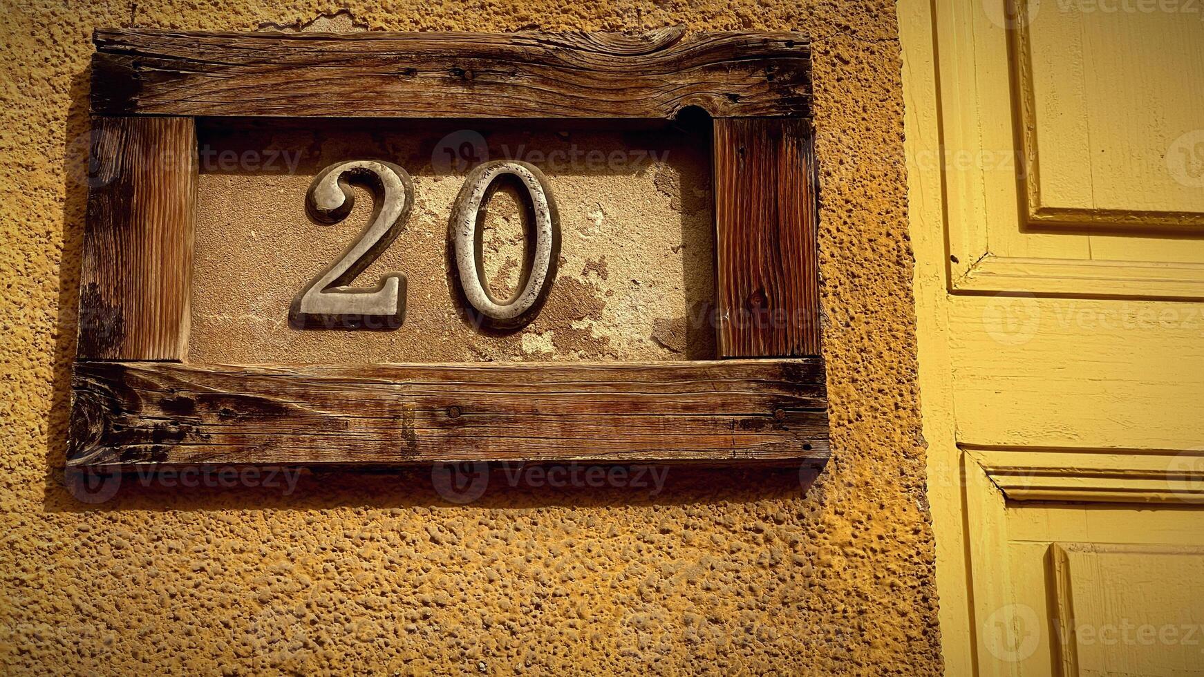 Charming house number on a textured wall in sunlight photo