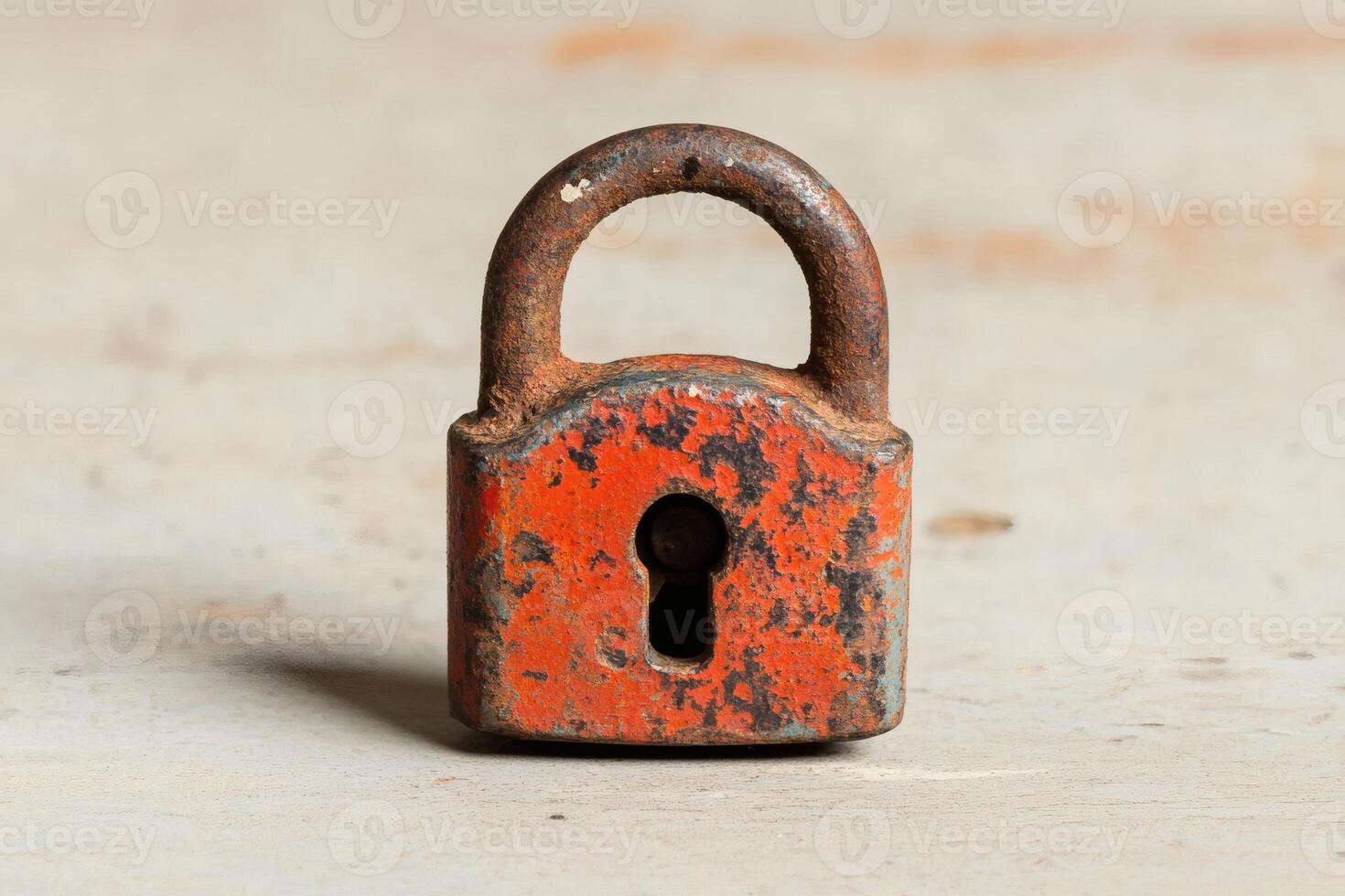 Weathered padlock resting on a rustic surface. photo