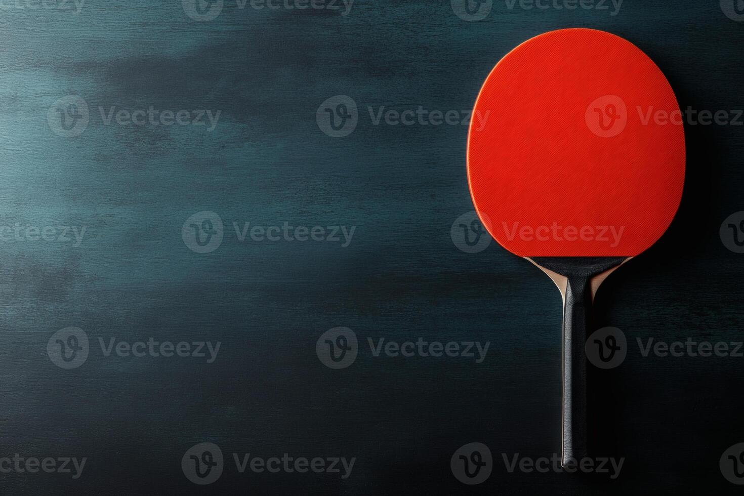Bright red paddle resting on a dark background. photo