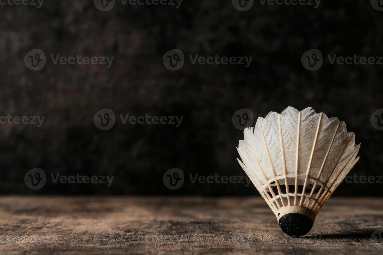 Shuttlecock resting on a rustic wooden surface. photo