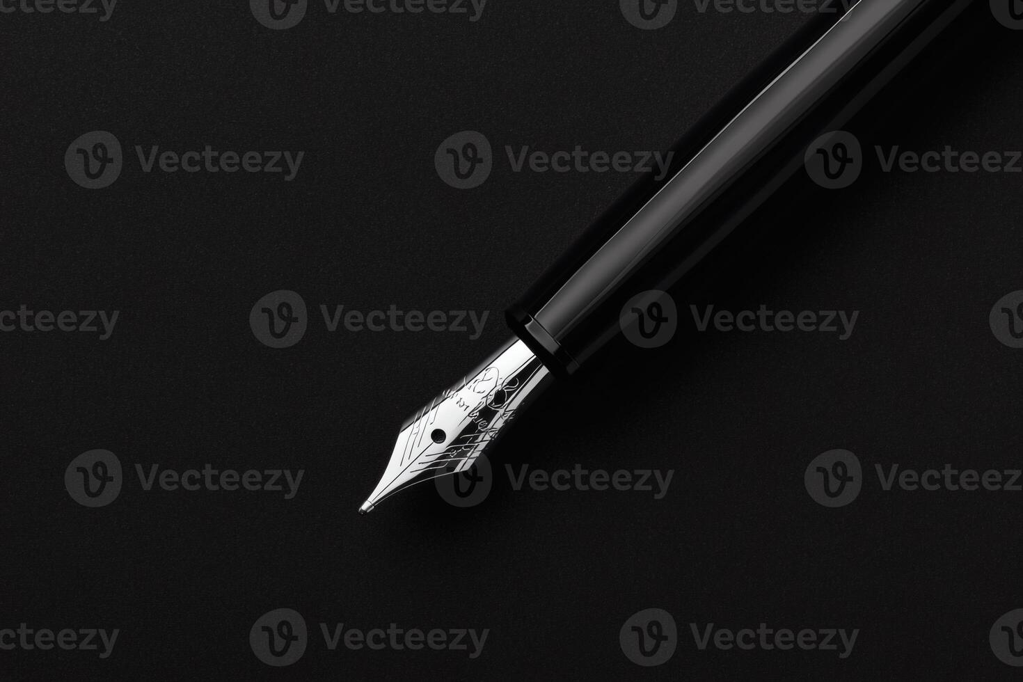 Elegant fountain pen resting on a dark surface. photo