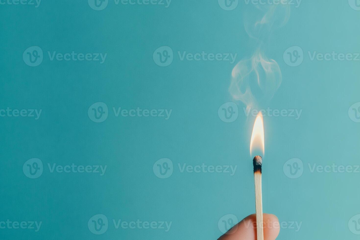 Lighting a match against a turquoise backdrop. photo