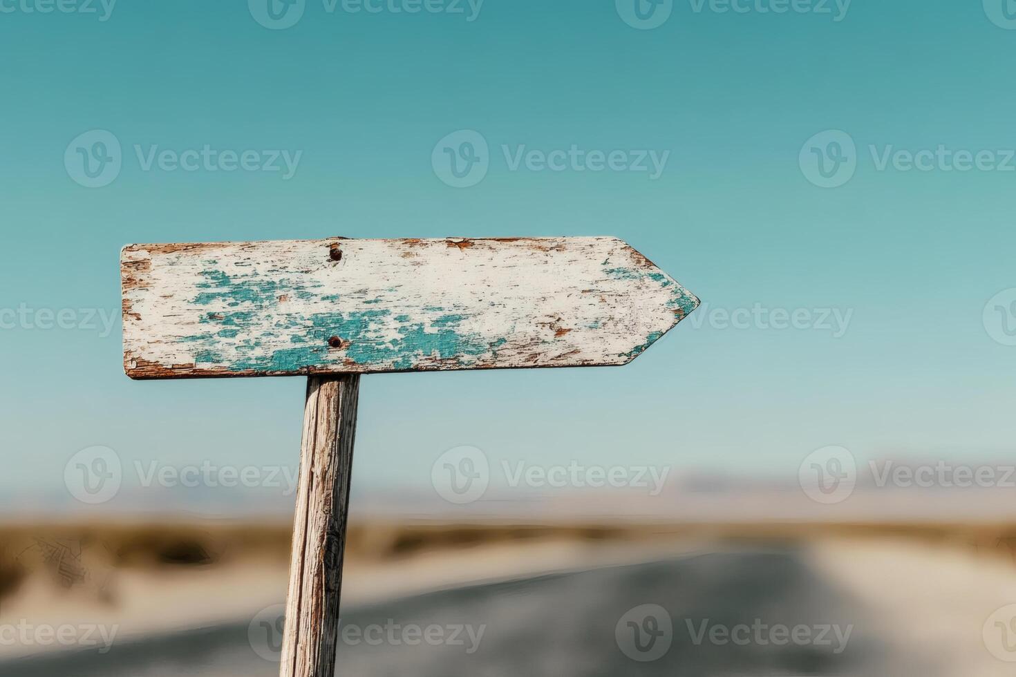 Rustic wooden signpost along a tranquil desert road. photo