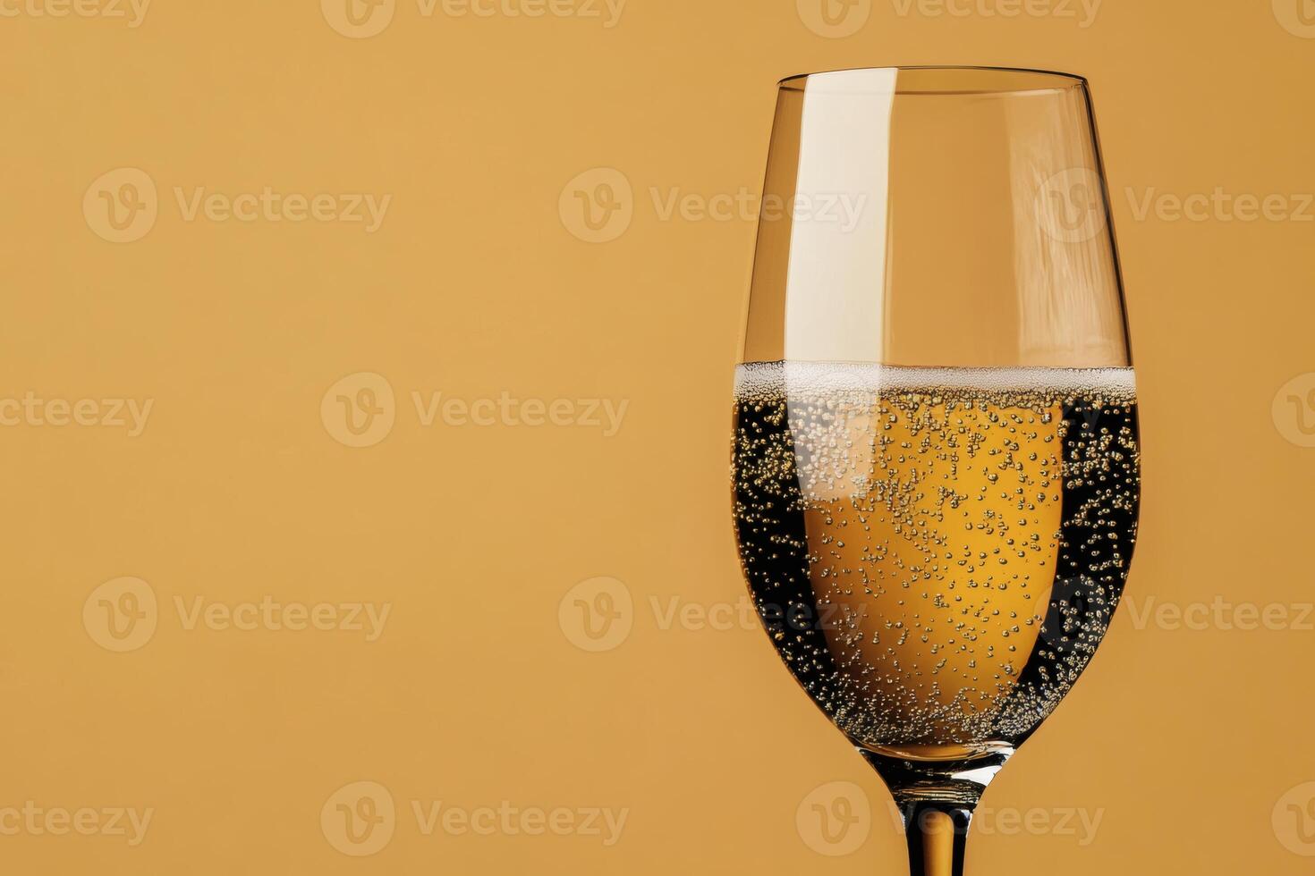 Sparkling beverage in a clear glass against golden backdrop. photo