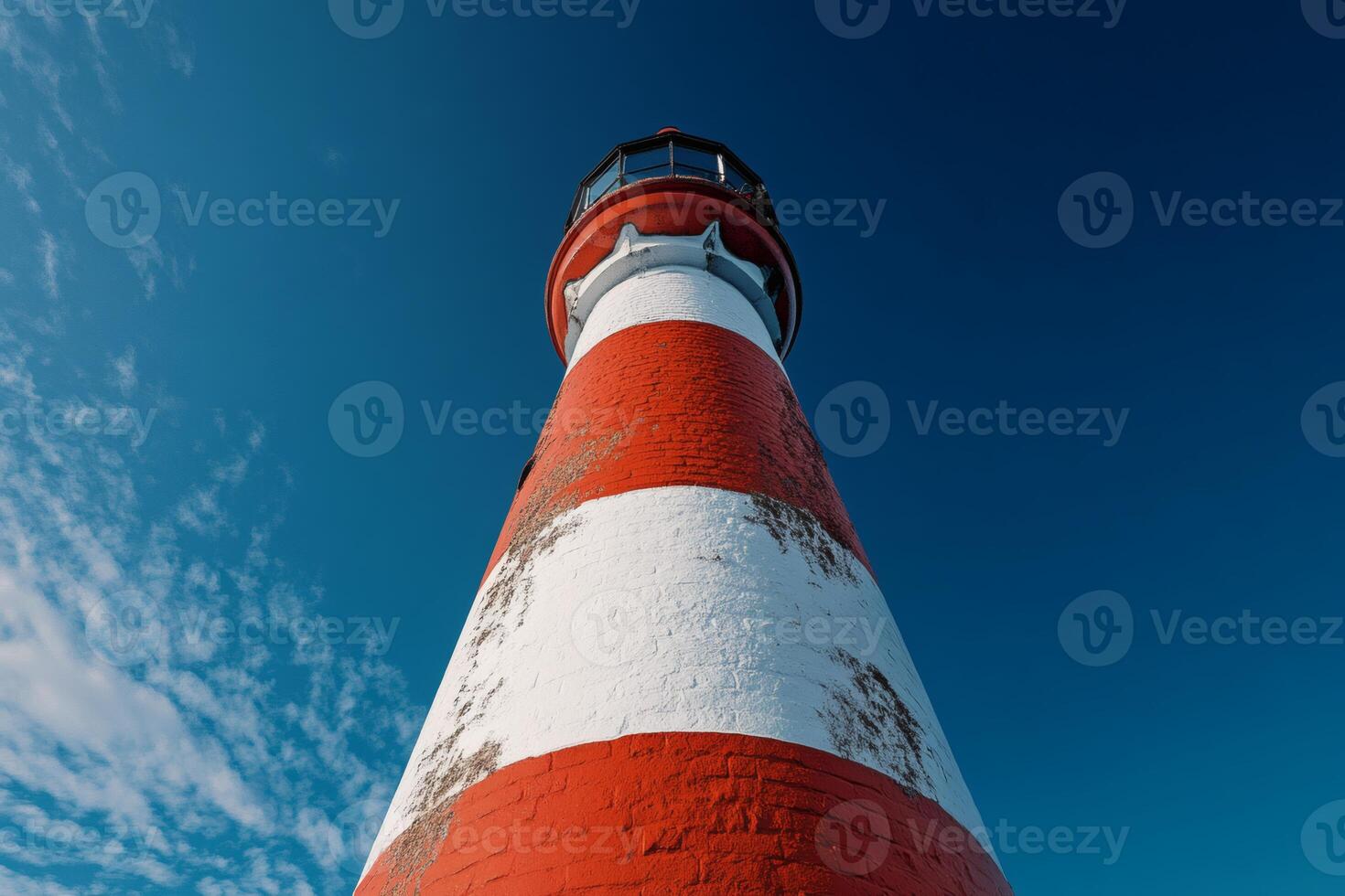 Vibrant lighthouse standing tall against the deep blue sky. photo