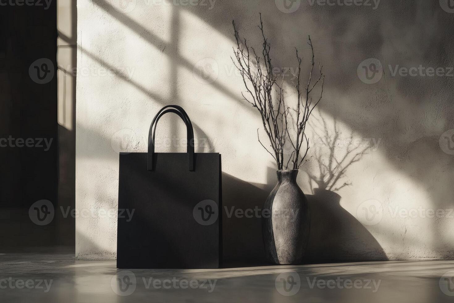 Elegant display of a black bag and minimalist vase in warm sunlight. photo