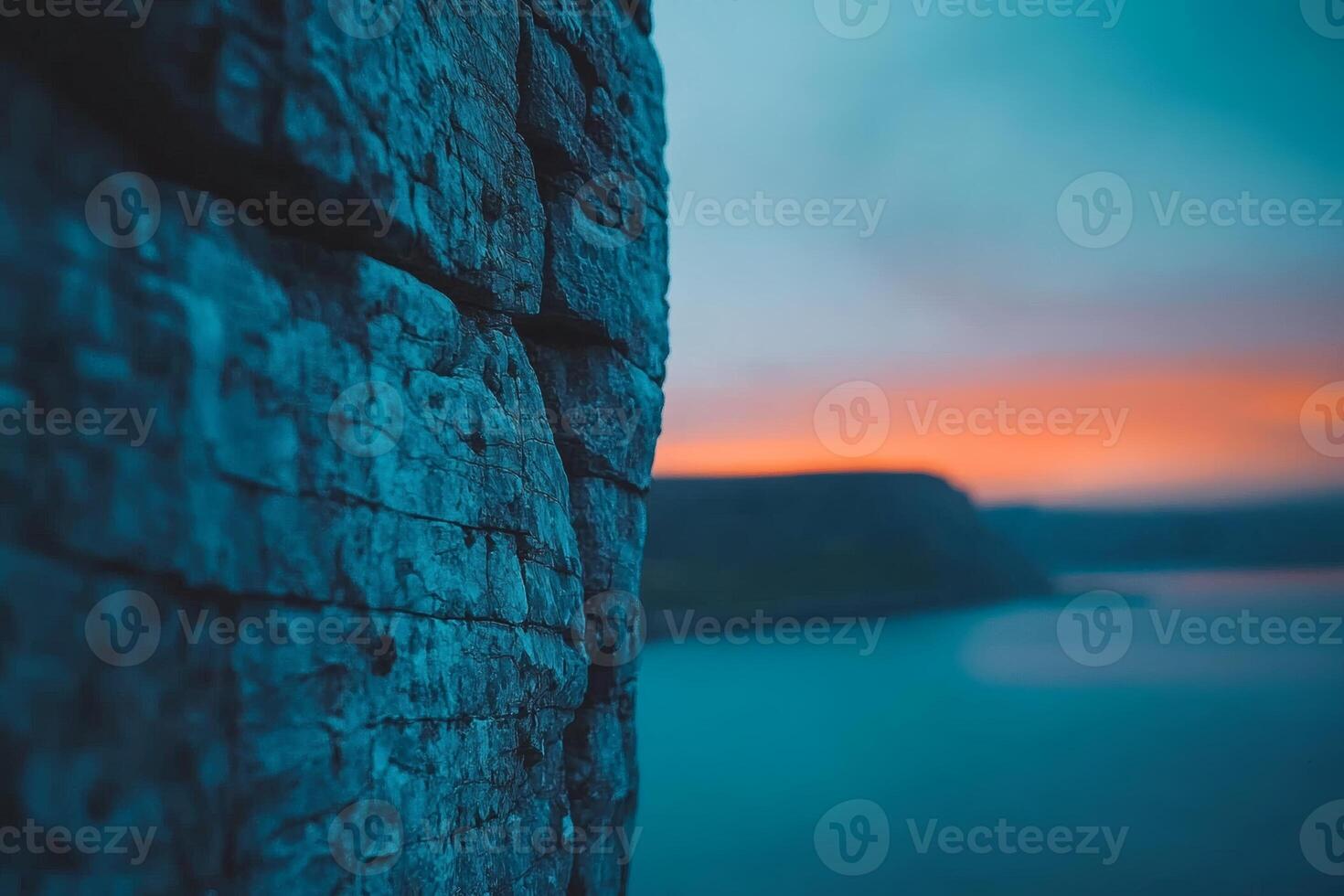 Vibrant sunset glimpsed through rugged cliffs photo