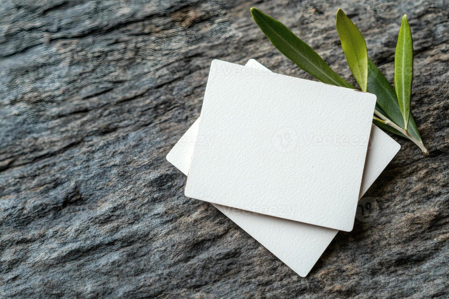 Blank cards resting on textured stone surface photo