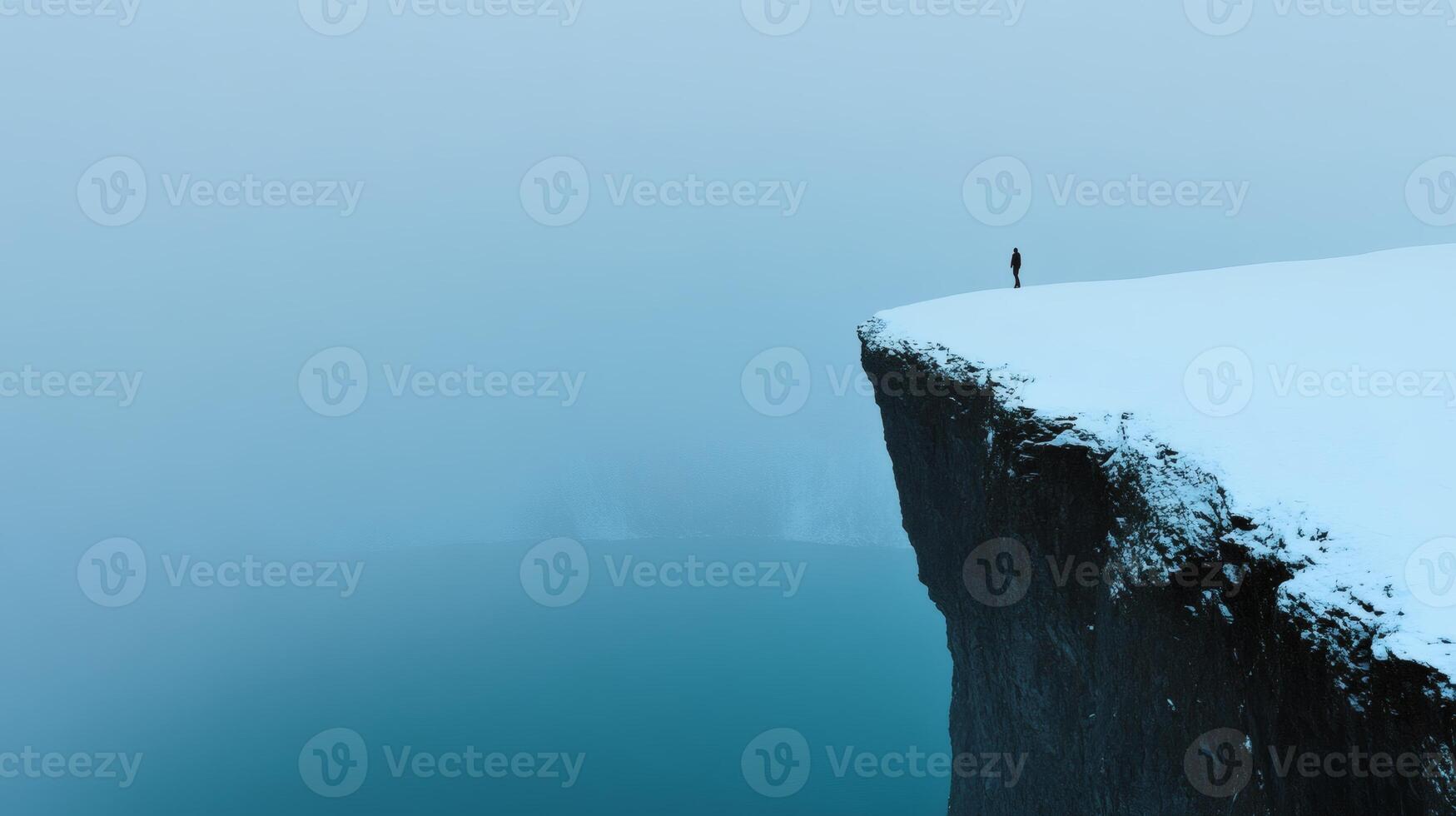 Solitary figure at a misty cliff edge photo