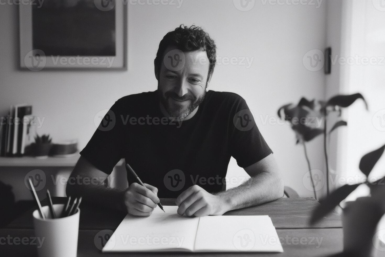 Creativity flows as a man sits at a wooden table, immersed in writing with passion in a softly lit indoor space filled with greenery photo