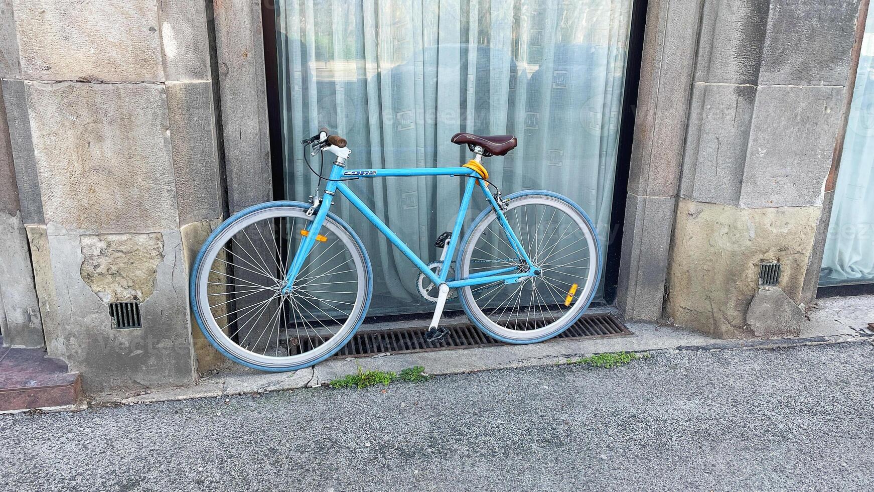 Bicycles resting by building with elegant window attire photo