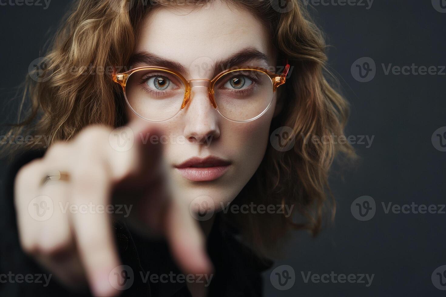 Striking confidence radiates from the model with curly hair and chic glasses, set against a dramatic dark backdrop photo