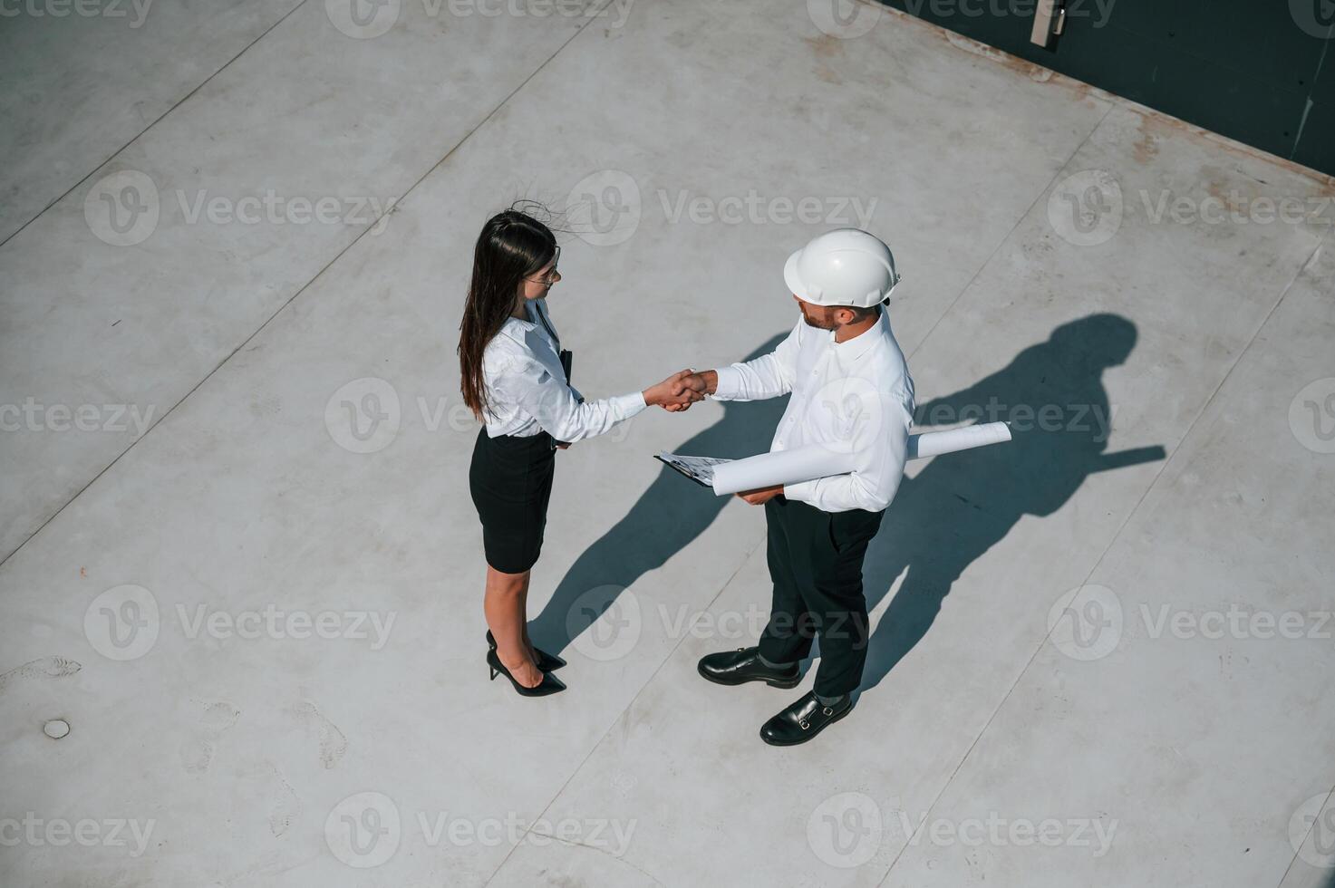 Successful, deal, doing handshake. Man with woman are working on the construction project together outside photo