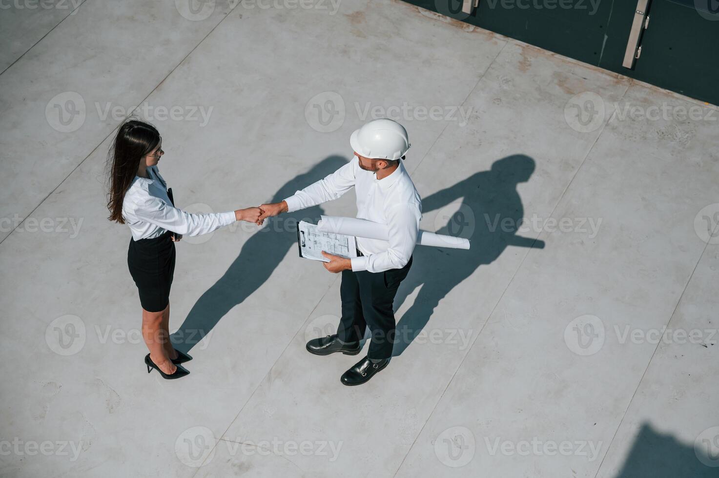 Successful deal, doing handshake. Man with woman ,are working on the construction project together outside photo