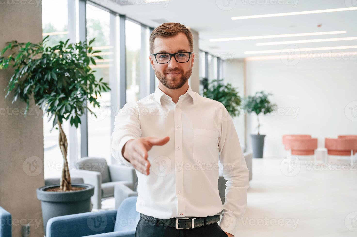 Giving hand ,to make handshake. Elegant man in formal clothes is indoors photo